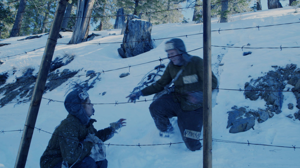 Andrey Vasilyev charges down snow hill to Gulag concentration camp fence, at moment of escape.